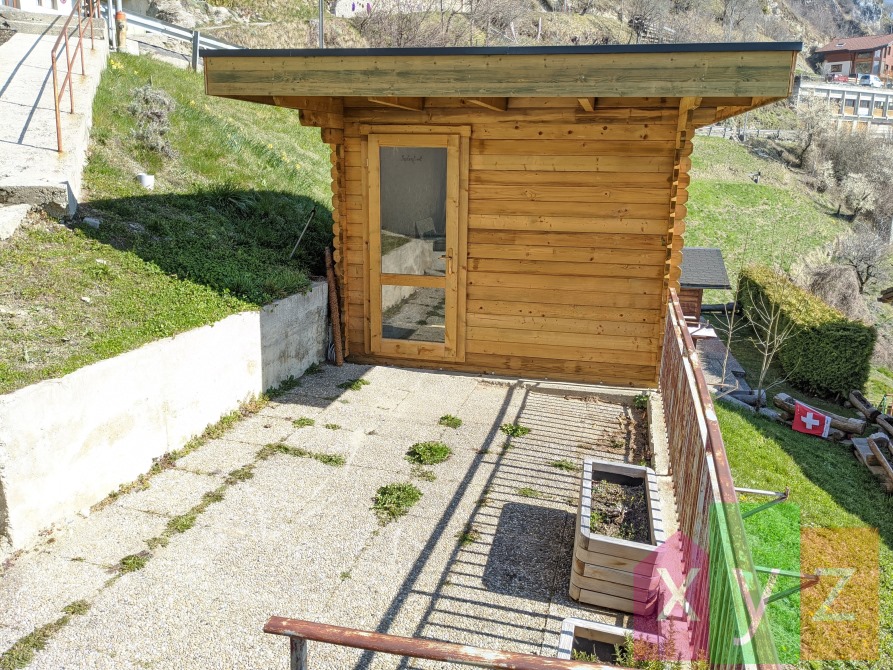 La terrasse de ~14 m2 devant la maison et le cabanon