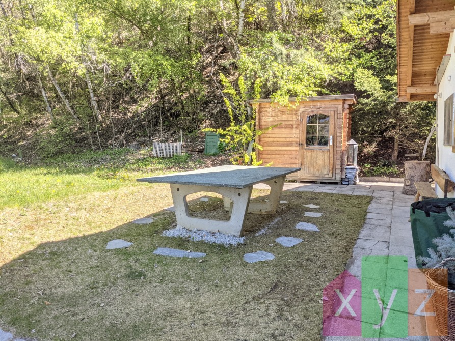 Le jardin et table à l’Est du chalet avec sa cabane à outils