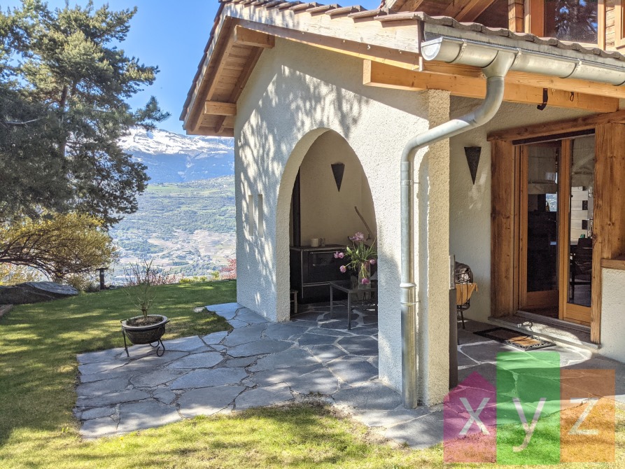 La terrasse couverte de ~16 m2 avec son fourneau et accès la cuisine