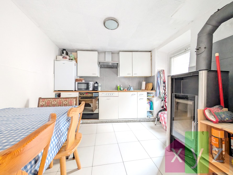 La cuisine agencée et son poêle à bois permettant de chauffer toute la maison