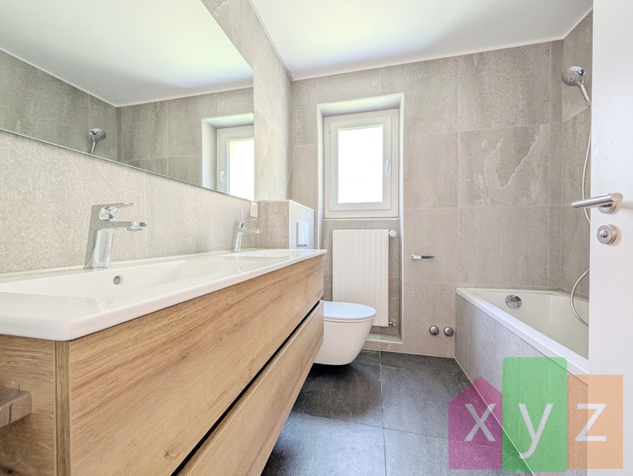 La salle de bain intemporelle équipée d'une baignoire, d'une fenêtre et d'une double vasque